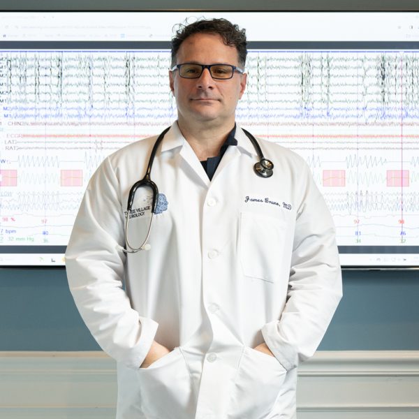 A doctor in a white coat with a stethoscope stands in front of a screen displaying medical data. A doctor in a white coat with a stethoscope stands in front of a screen displaying medical data.